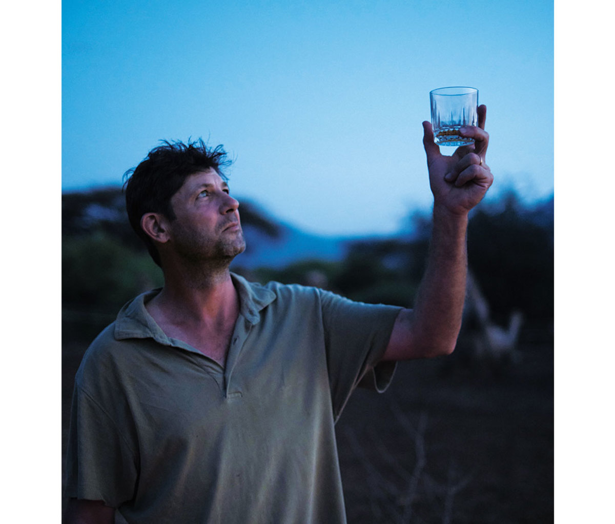 Caucasian man holding glass of water up