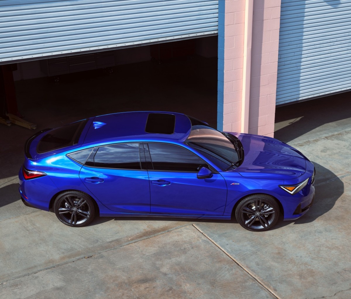 Blue Acura Integra pulling out of a garage