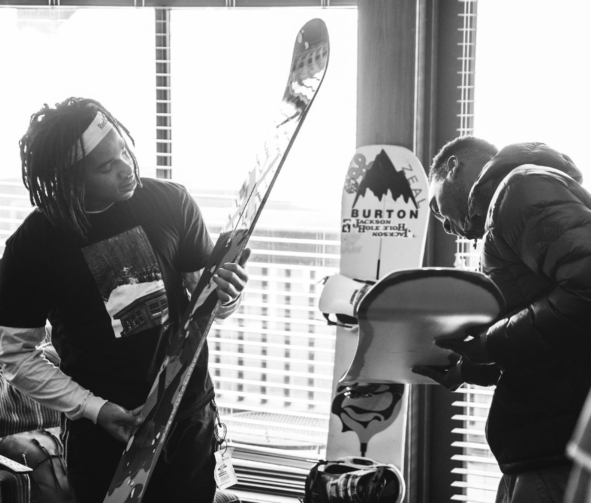 Black and white photo of Black men looking at snowboards