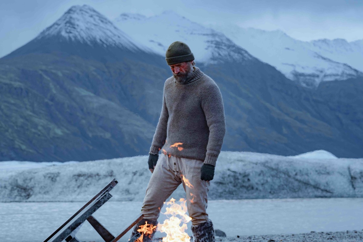 Nikolaj Coster-Waldau arms himself by a fire in the Arctic during a scene from "Against the Ice"