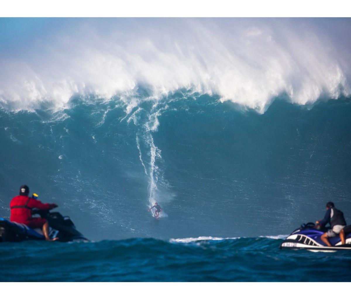 Kai Lenny rides toward the base of a big wave.
