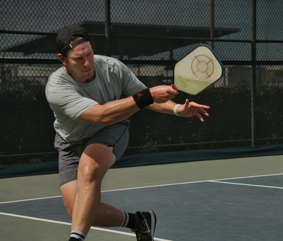 Man lunging on court with racket in hand