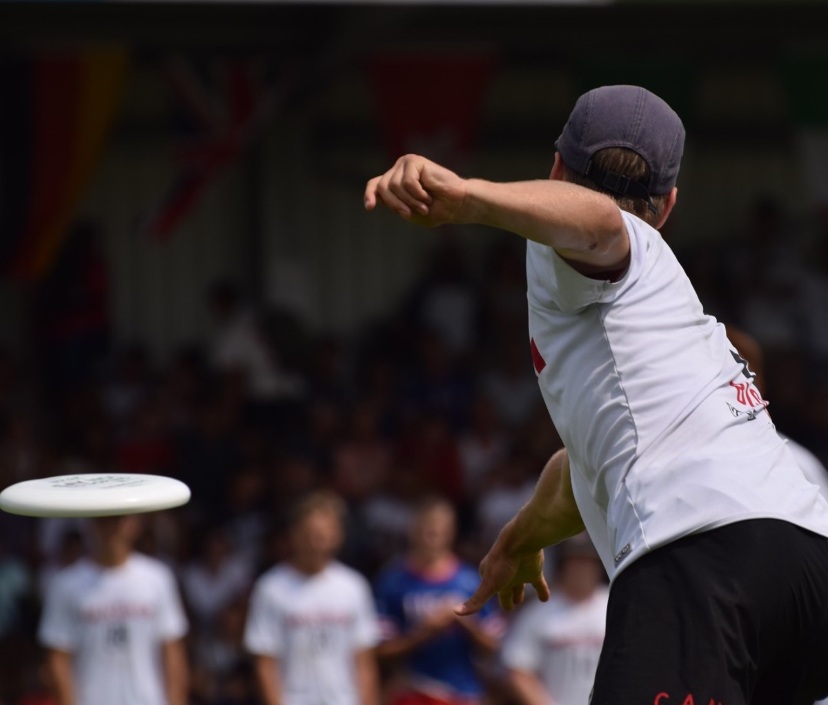 Man in white T-shirt throwing frisbee
