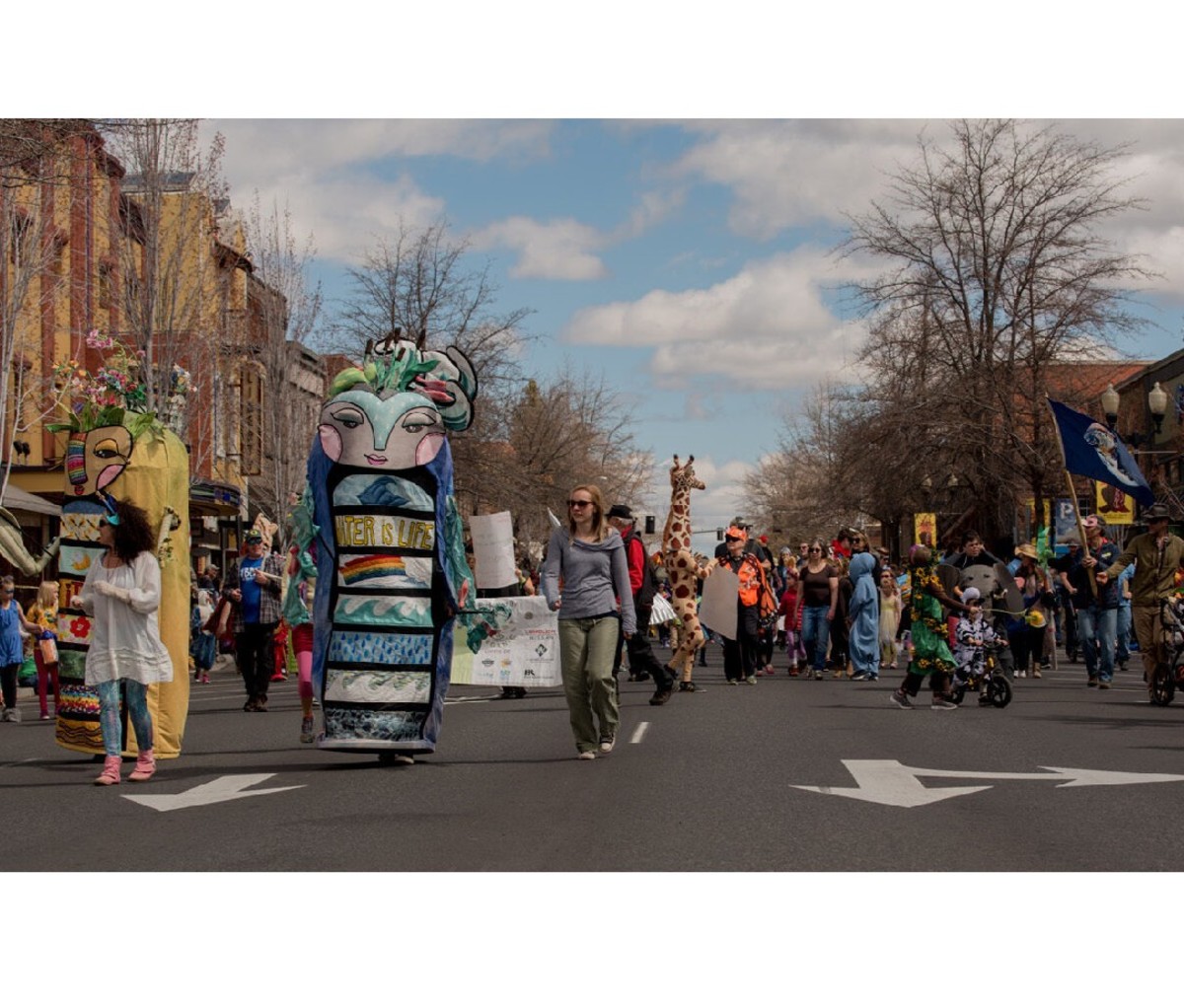Families parading down the street in downtown Bend, OR, during Earth Day Fair & Parade