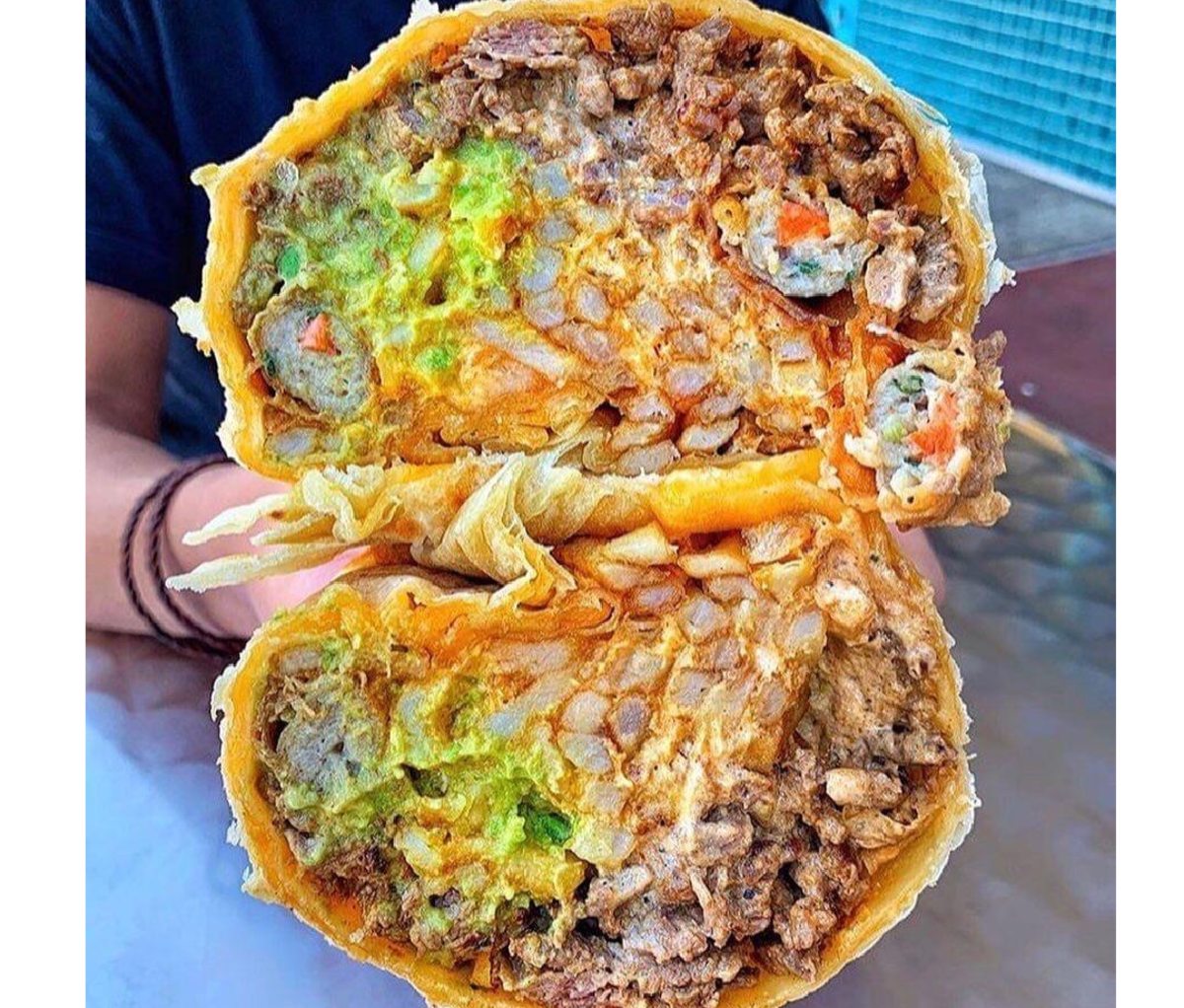 Two stacked halves of a burrito held at Sayulitas Mexican Food
