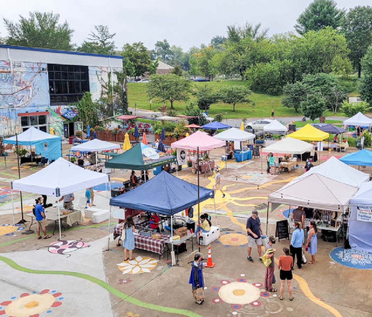 Aerial image of families gathered under colorful umbrellas at Earth Day at Ix Art Park in Charlottesville, VA