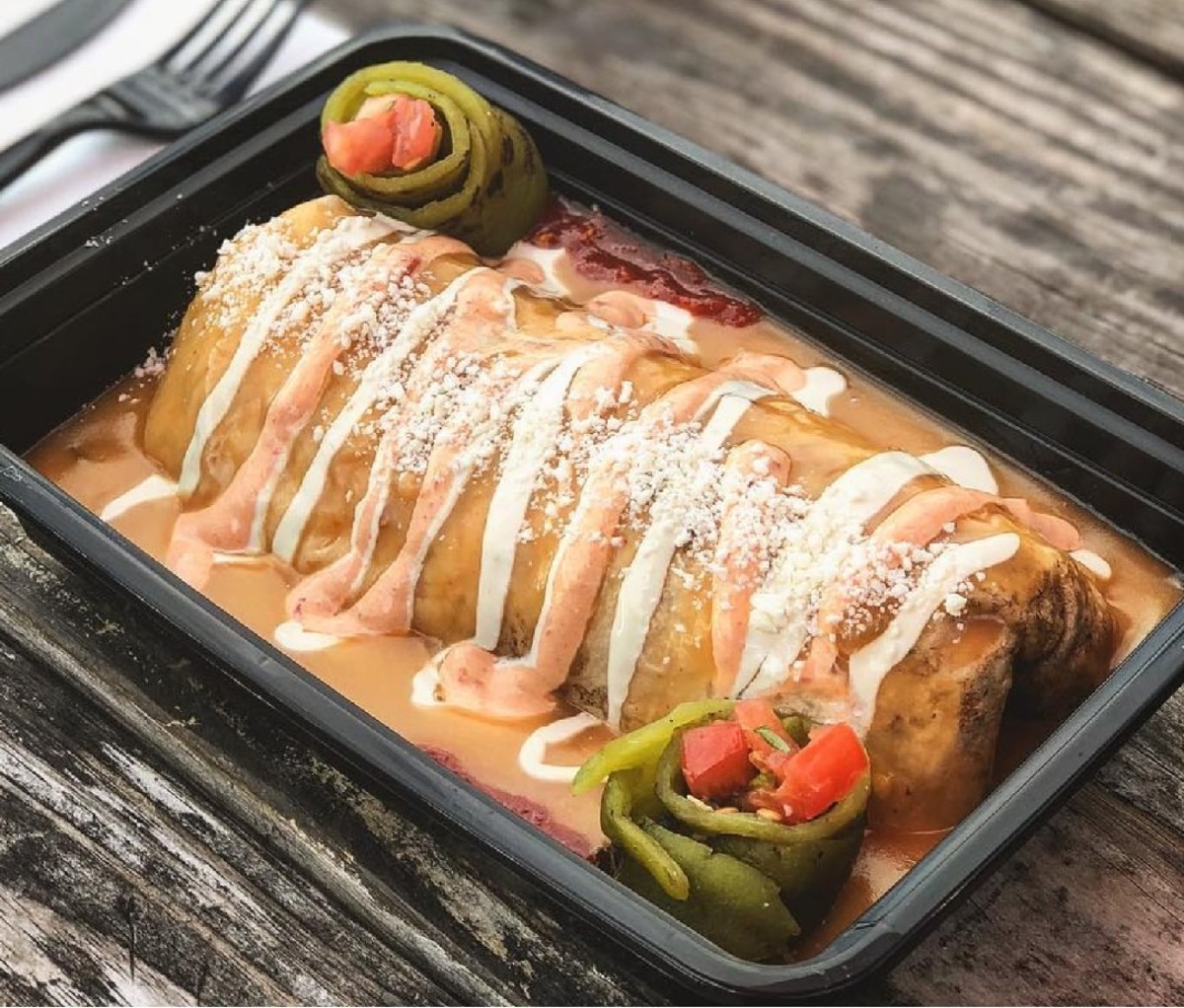 Wet burrito in a black plastic dish from Bonfire Burritos