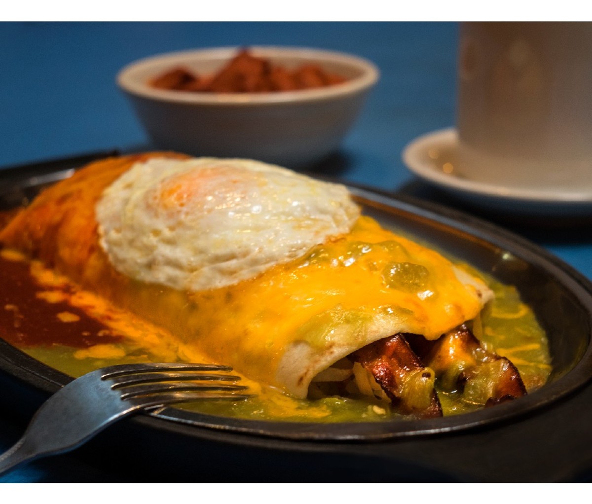 Cheese smothered burrito with a fried egg on top from Tia Sophia’s