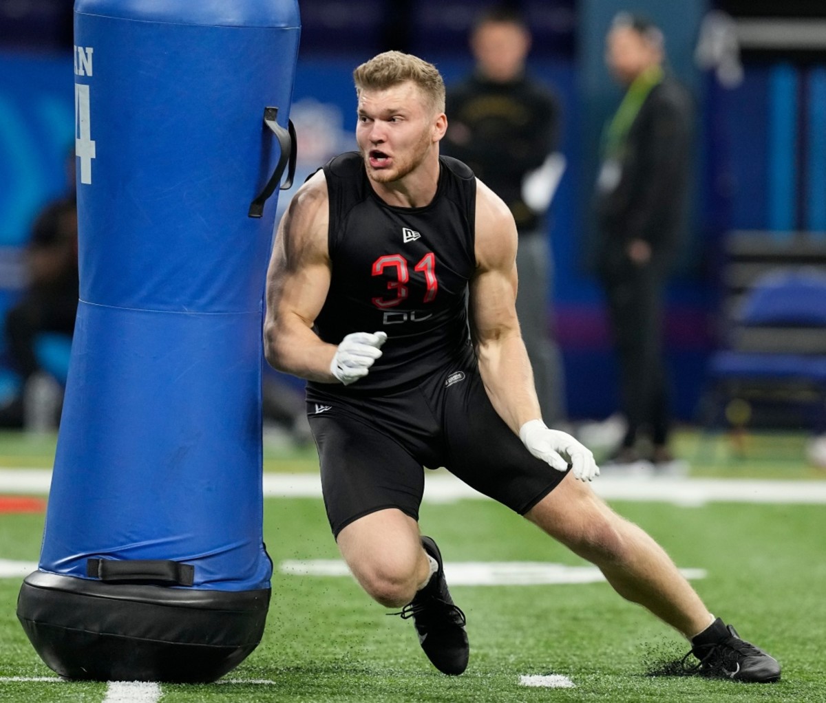 NFL Draft 2022: Michigan defensive lineman Aidan Hutchinson runs around a blue cylindrical barrier during the NFL football scouting combine.