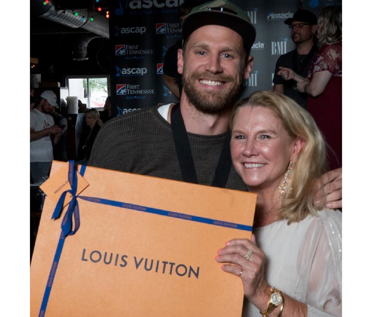 Chase Rice with his mom Connie Rice holding a large Louis Vuitton box.