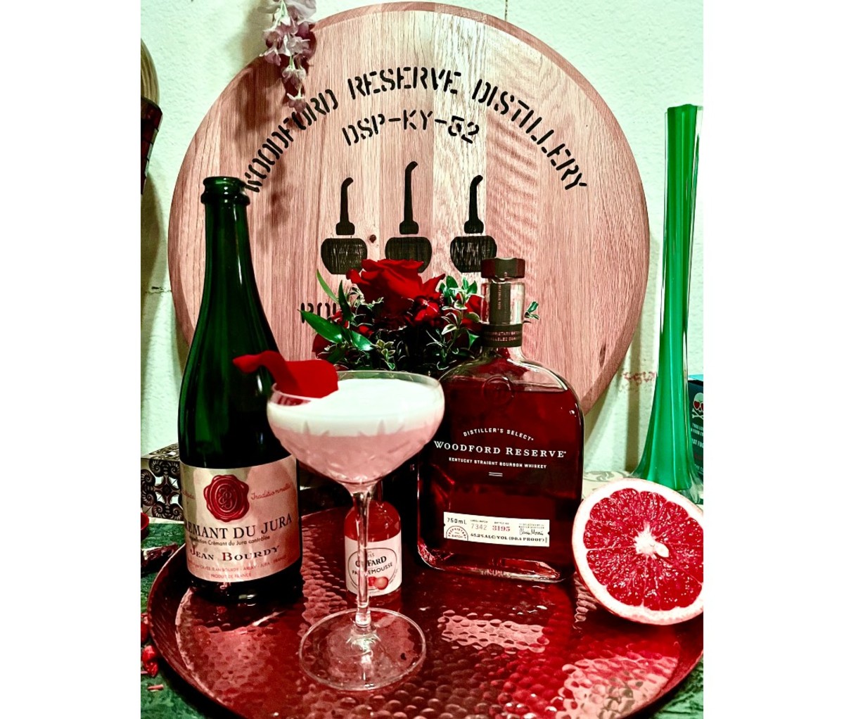 How to Make the Official $1,000 Kentucky Derby Bourbon Mint Julep: 2022 5 Pink cocktail with cream on top next to liquor bottles