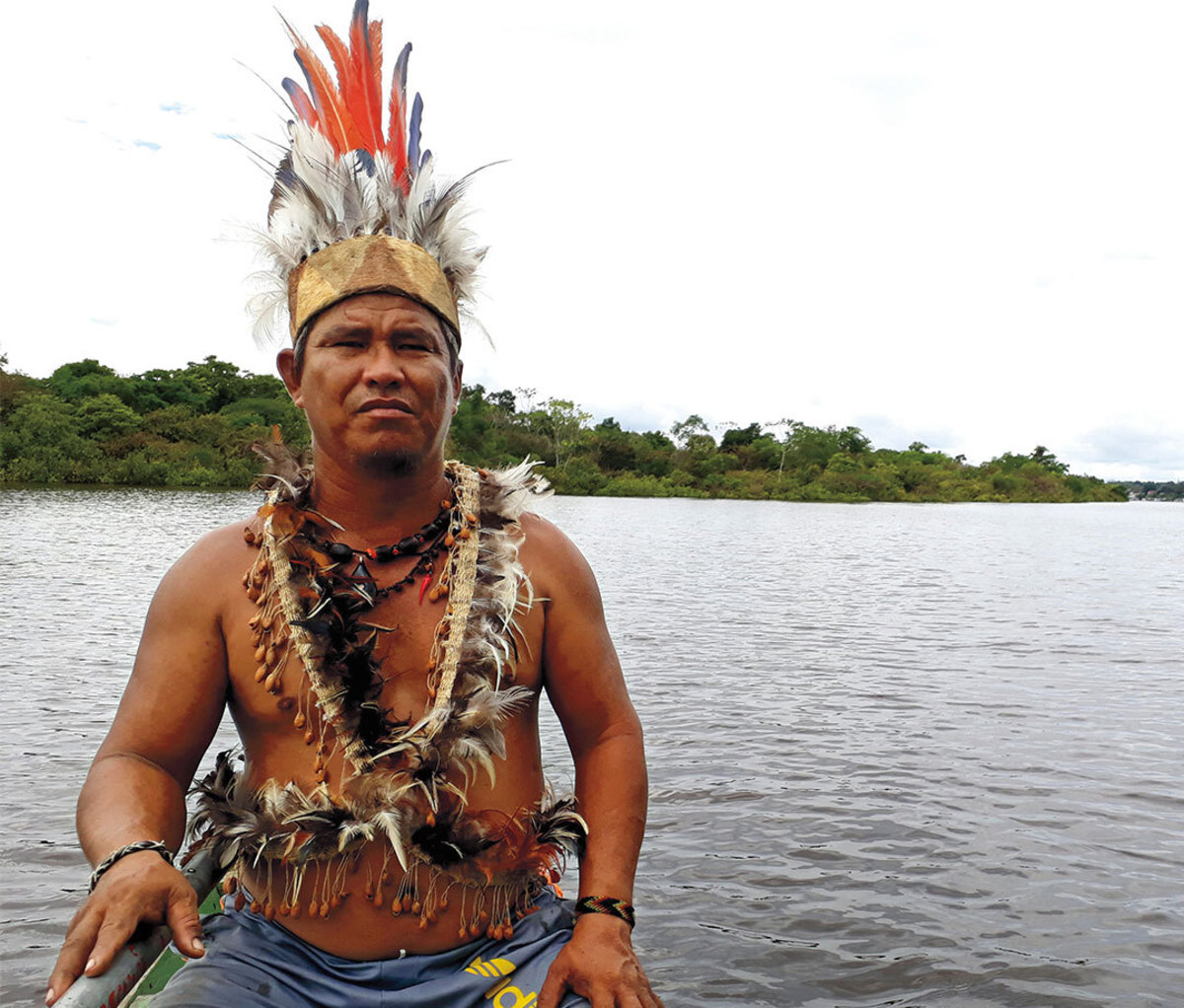 Indigenous leader sitting in boat on river