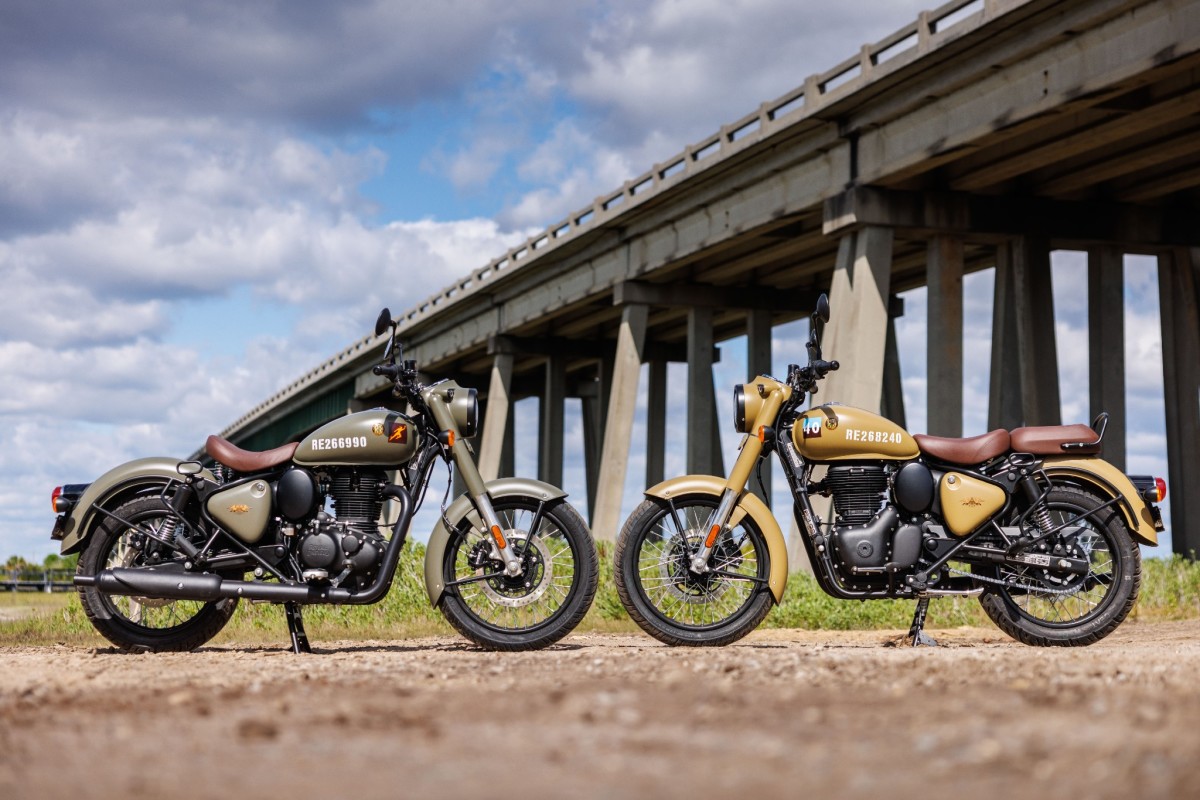 Two motorcycles facing one another with bridge in background