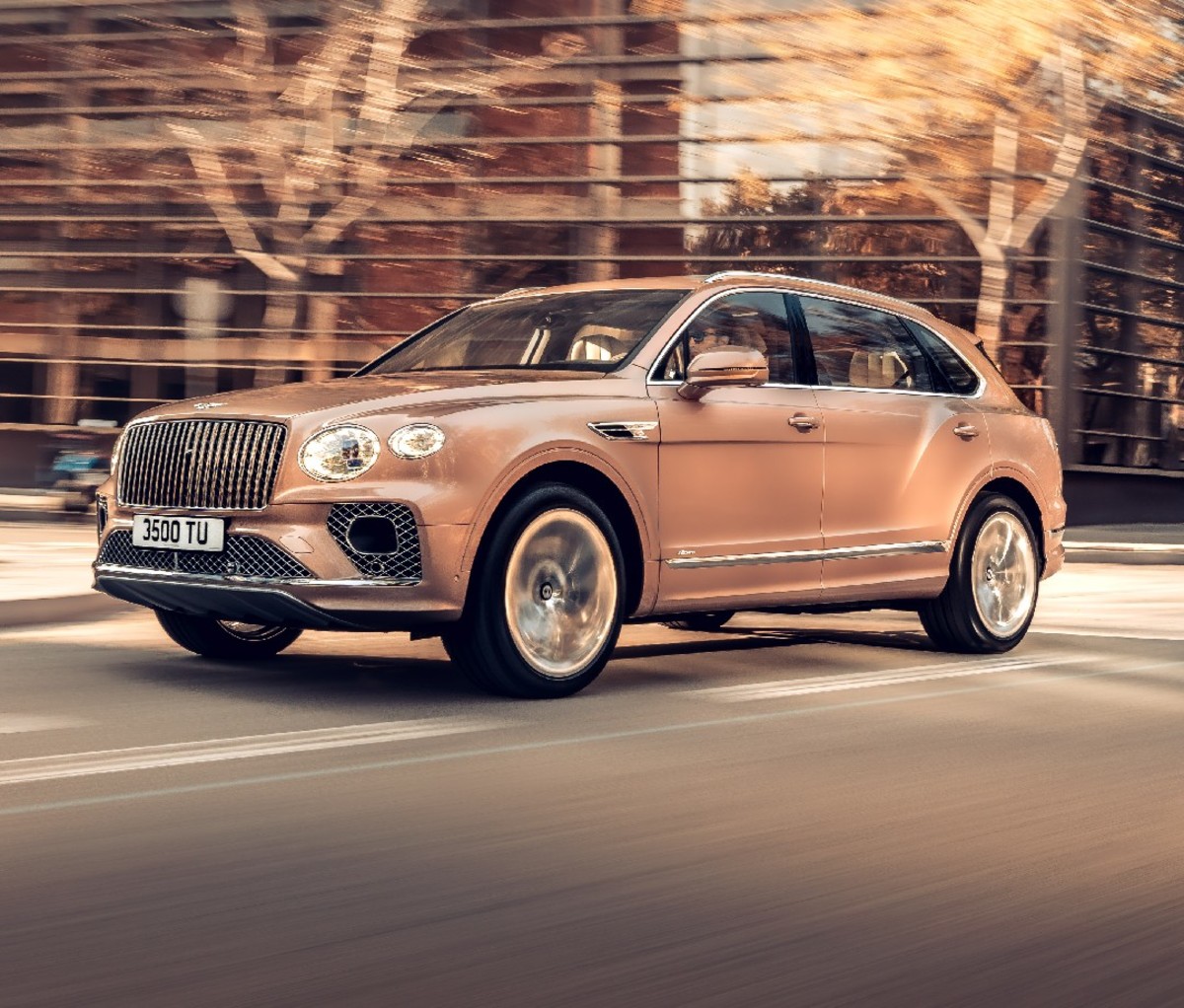 Rose colored 2023 Bentley Bentayga Extended Wheelbase, front side, driving on the road