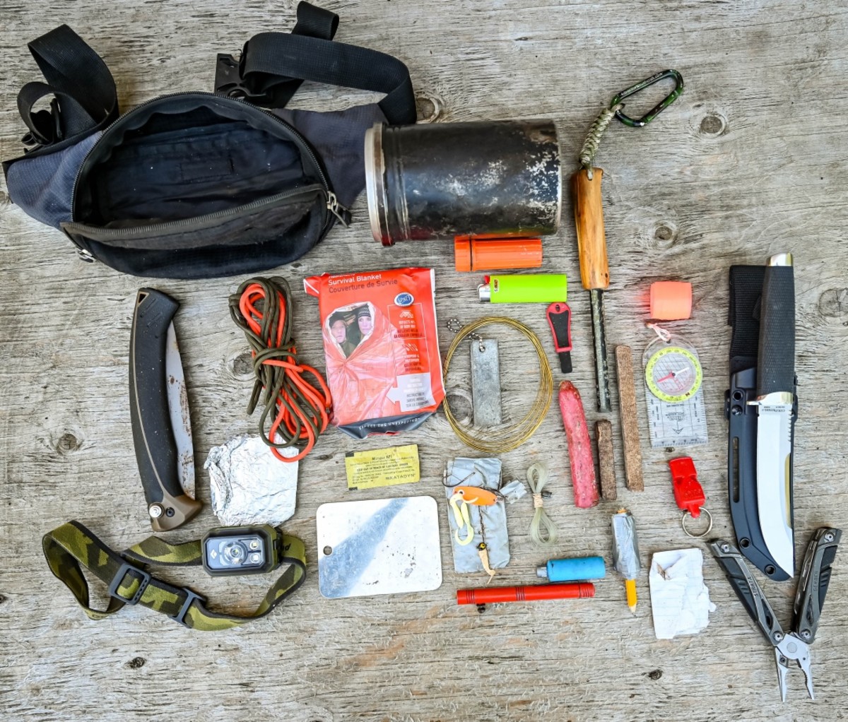 Jim Baird's survival kit laid out on a wooden table, viewed from the above.