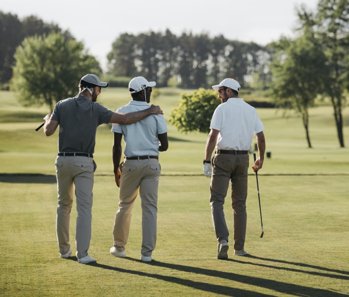 Three male golfers walking on golf course