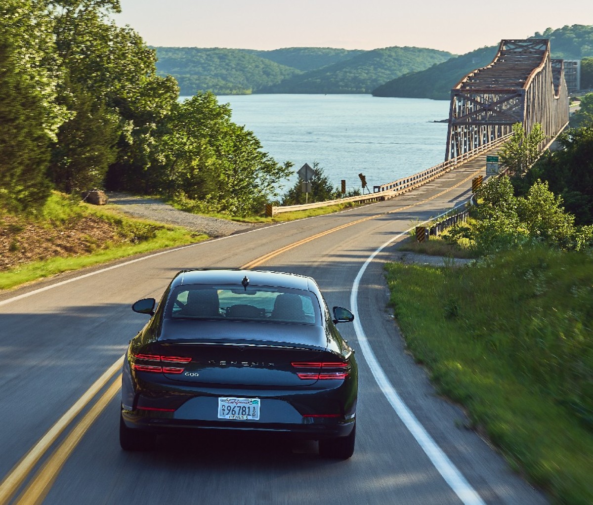 The Genesis Electrified G80 driving on the road, rear angle