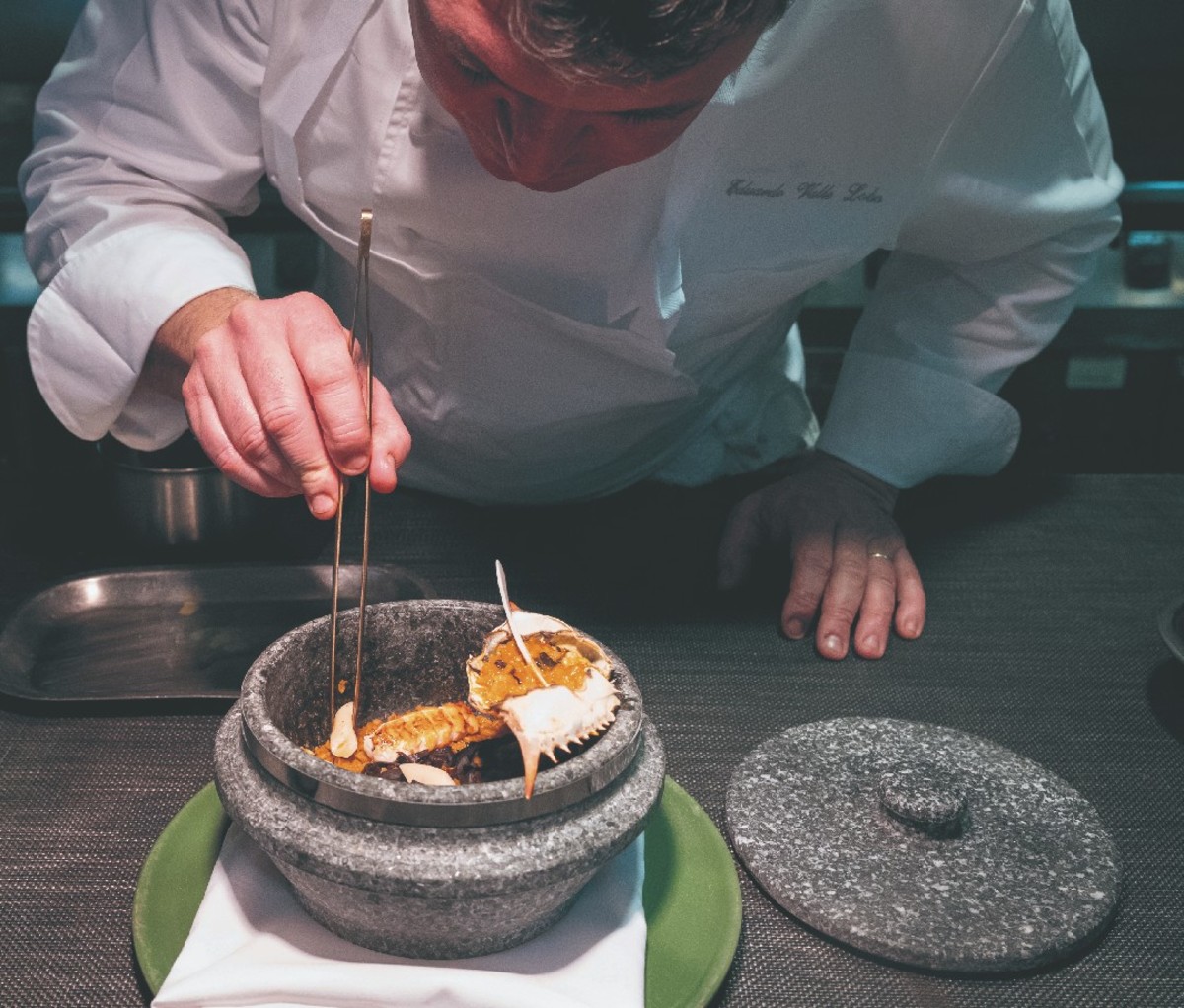 Chef preparing a dish of seafood over Mediterranean rice