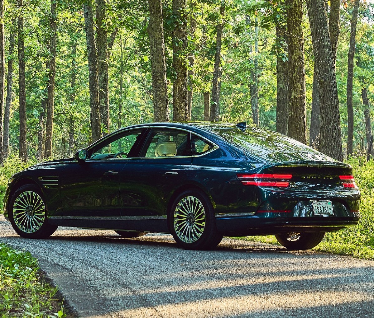 The Genesis Electrified G80 parked on a road in the woods.