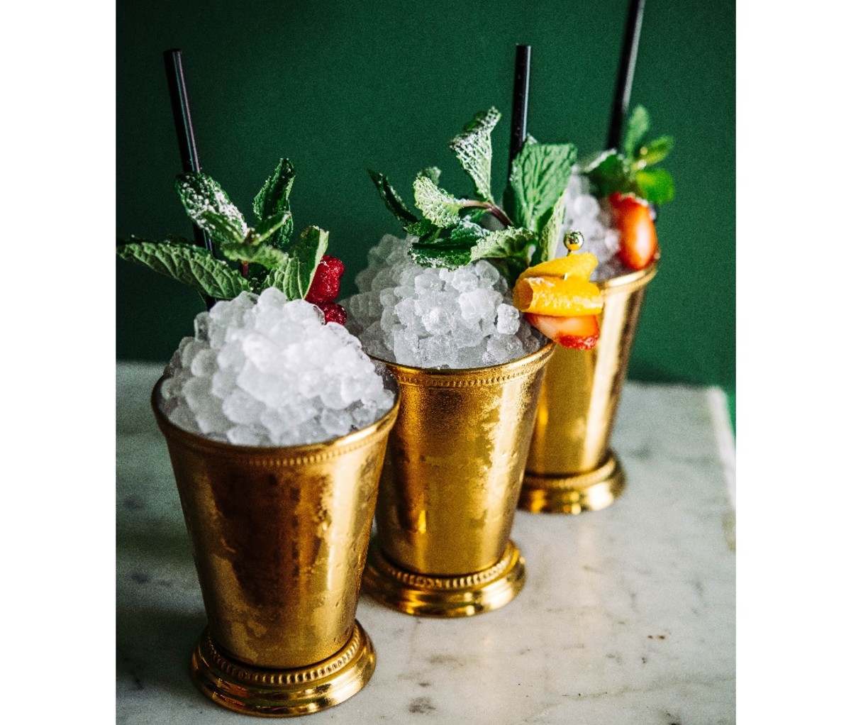3 King's Cobbler cocktails in metal julep cups lined up on a counter