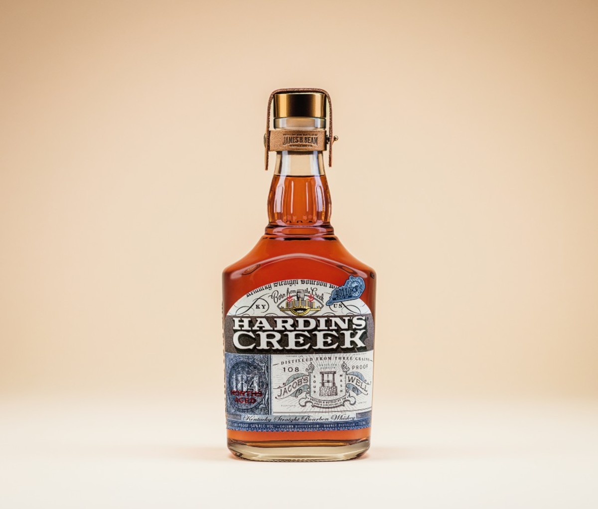 Bottle of Jacob’s Well Kentucky Straight Bourbon on soft orange backdrop