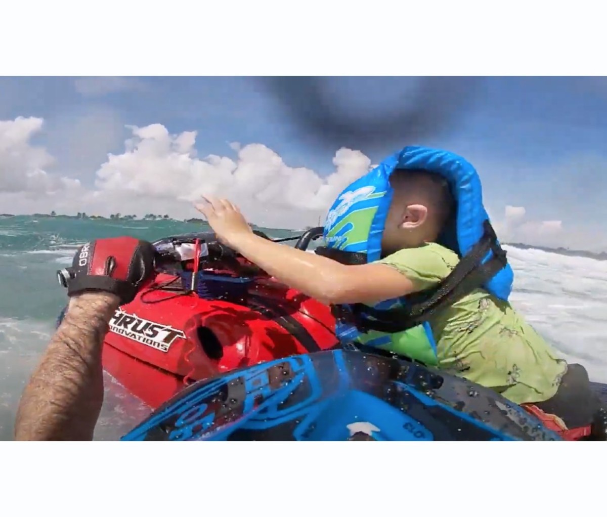 Little boy being rescued onto jet ski