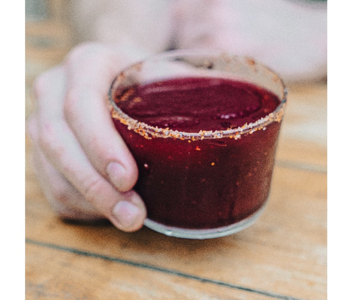 Hand holding a Sangre de Mezcal cocktail