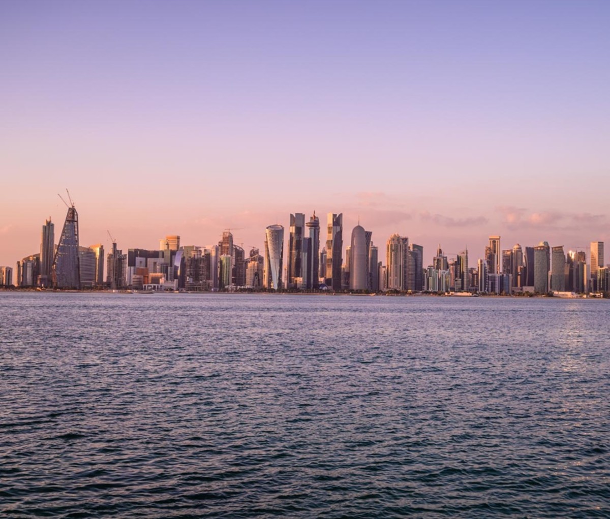 City skyline by water at sunset