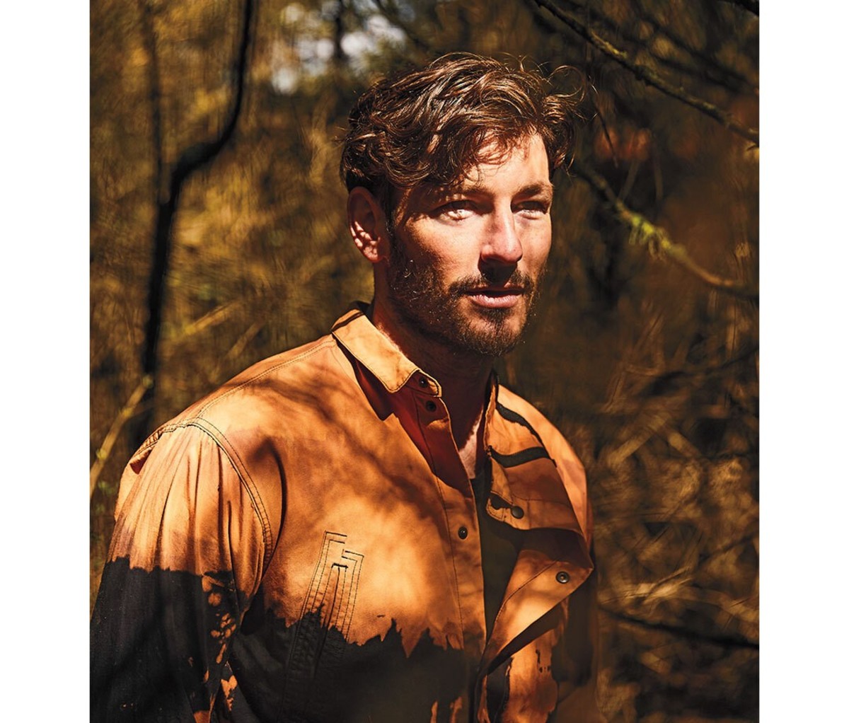 Man in the woods wearing a brown shirt
