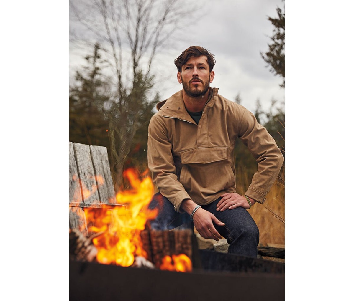 A man sitting next to a campfire