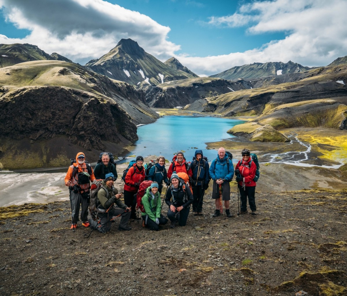 Group of people standing above a lake on a 57hours trip in Iceland.