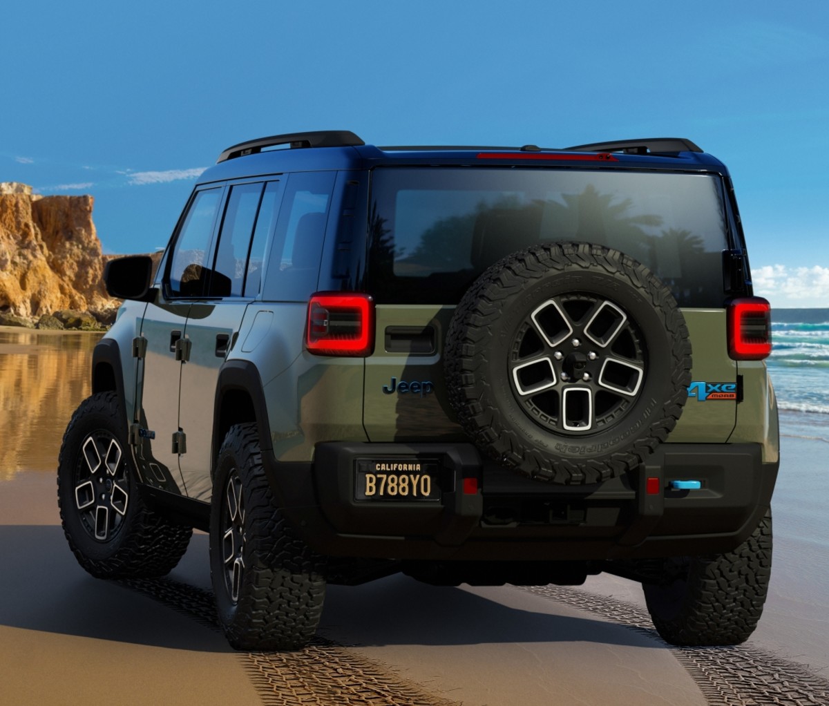 A green Jeep Recon parked on a beach, viewed from the rear.