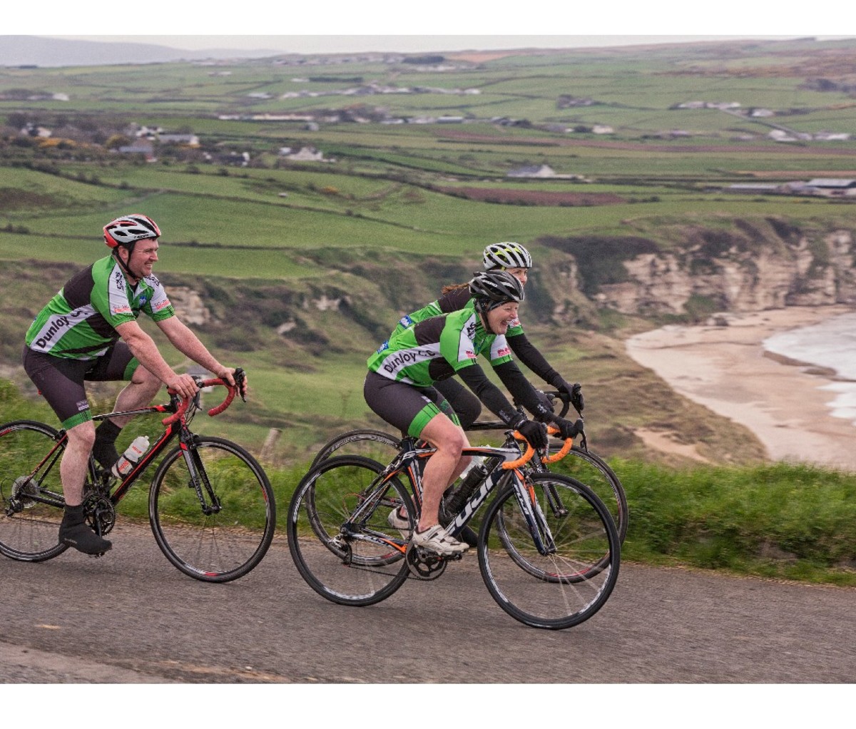 Bikers in green pedalling the coast of Ireland