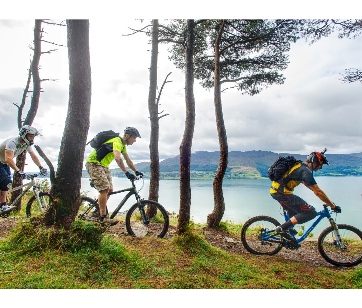 Three mountain bikers on the trail along the Irish coast.