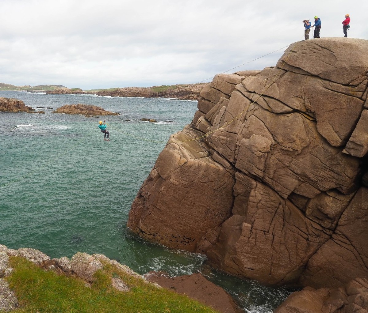 Adventurers ziplining/coasteering off the Irish coast