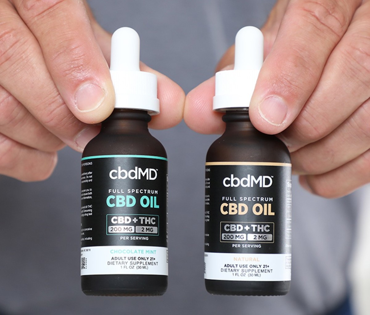 A man holding two bottles of CBD oil