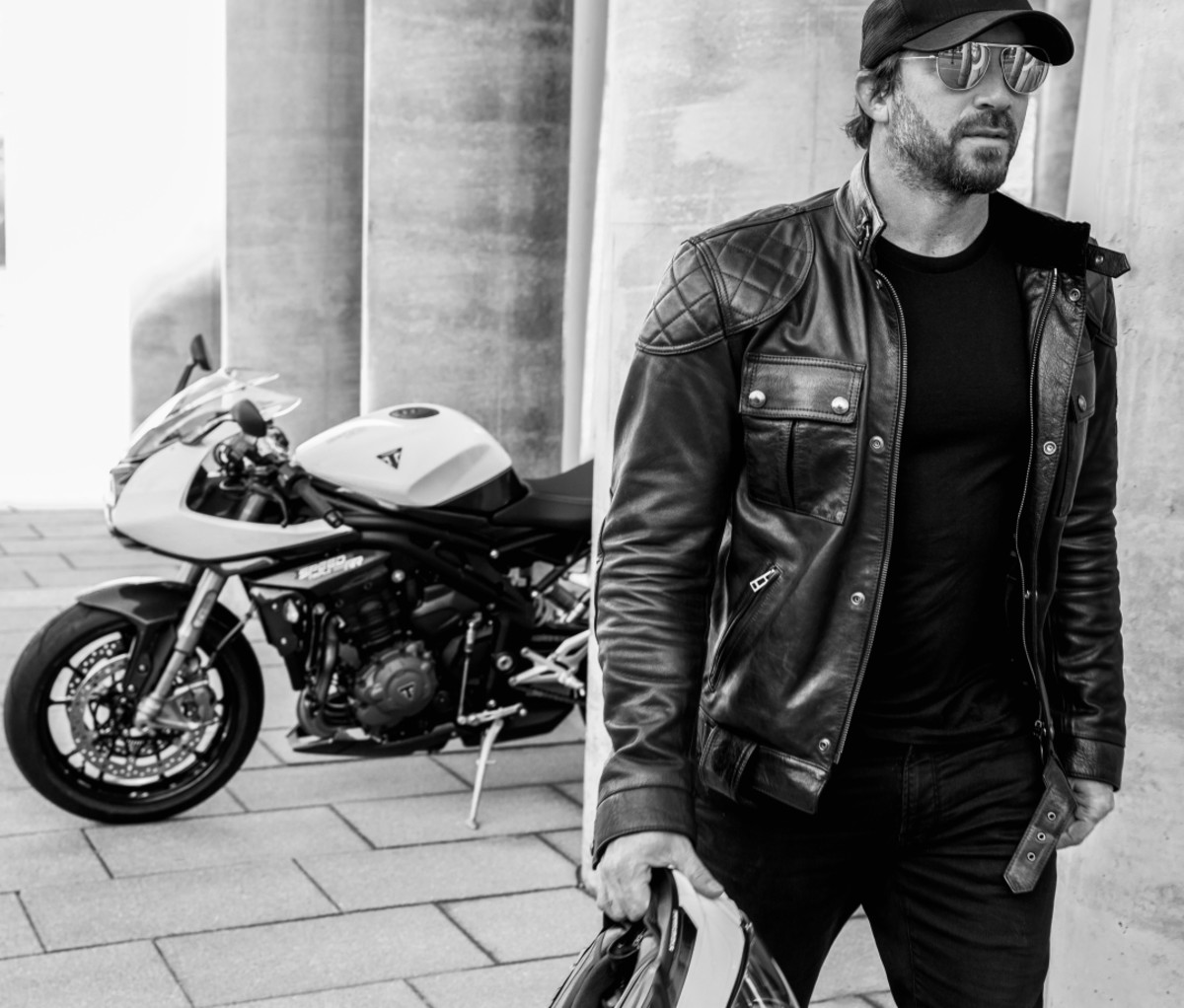 Man in a leather jacket walking away from a Triumph Speed Triple 1200 RR