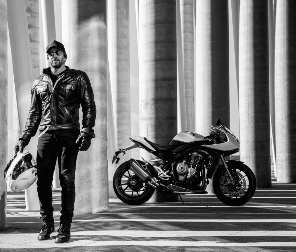 Man walking away from a parked Triumph Speed Triple 1200 RR.