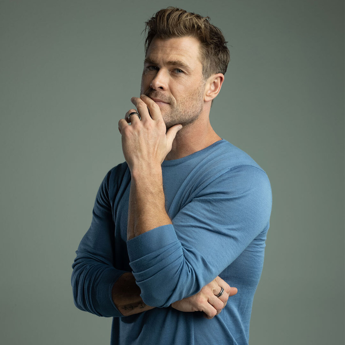 Actor Chris Hemsworth posing in blue henley