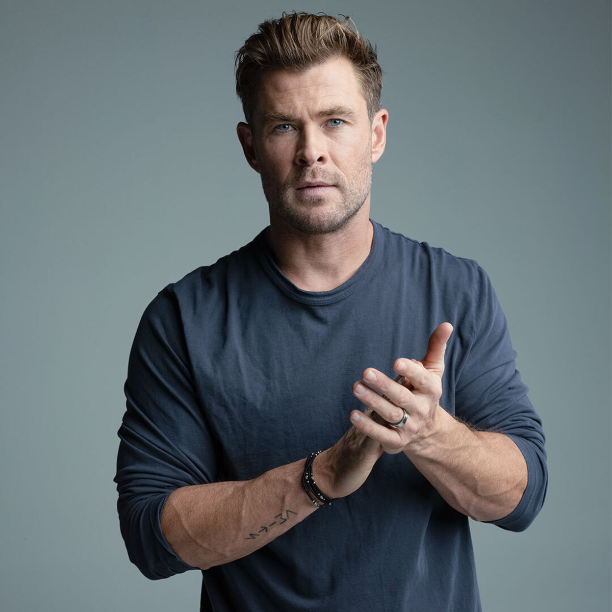 Actor Chris Hemsworth posing in navy shirt