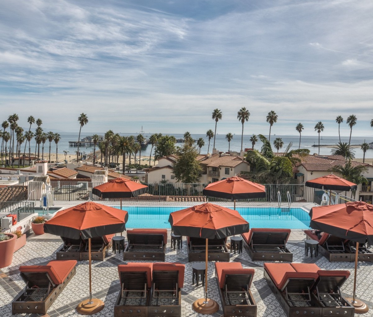 Rooftop pool overlooking Pacific ocean and palm trees