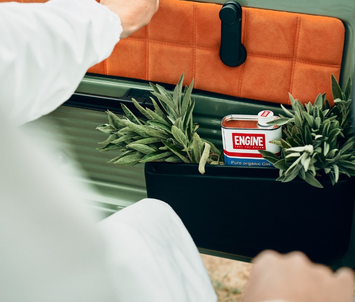 Can of Engine Organic Gin in car door with fresh sage