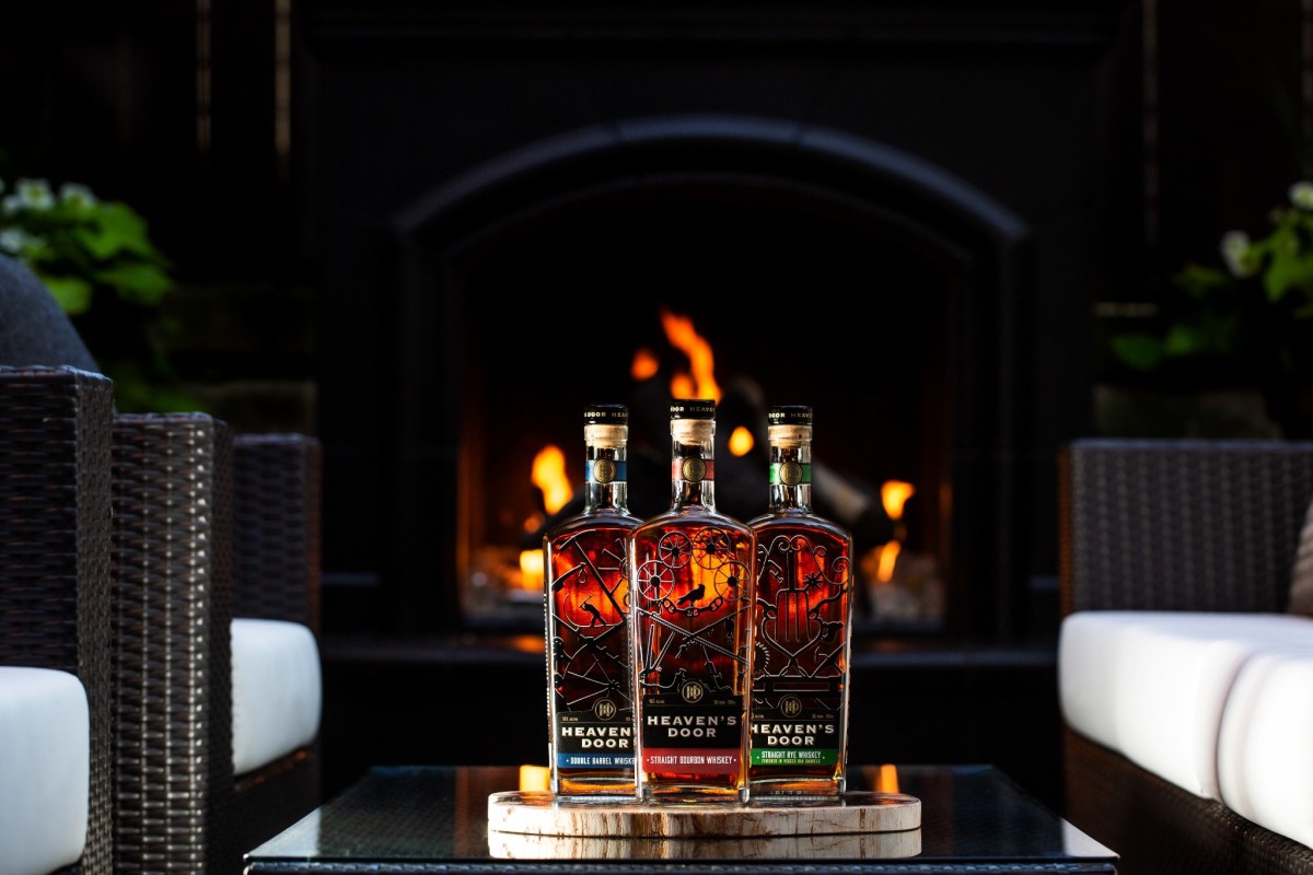 Trio of whiskey bottles on table in front of fireplace