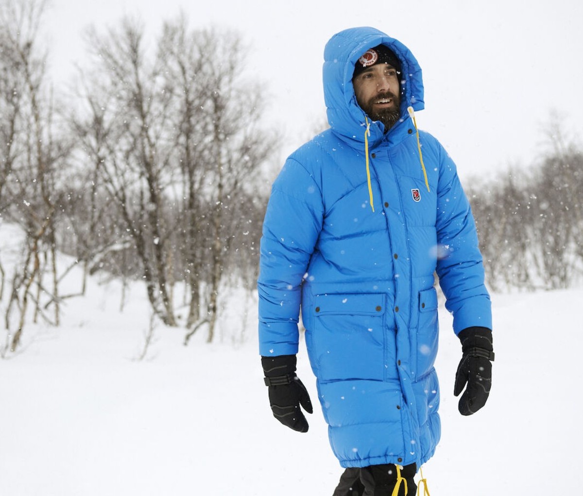 Man wearing long blue parka in snow