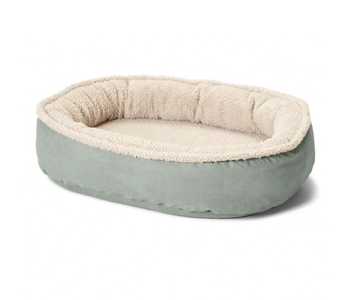 Green and white oval dog bed on a white background.