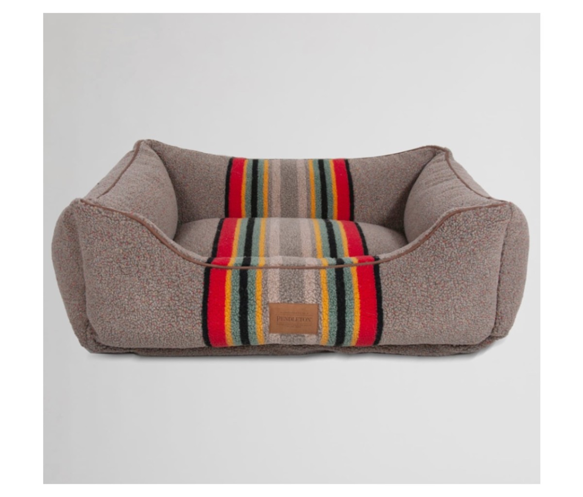 Gray and multi-striped dog bed on an off-white background.