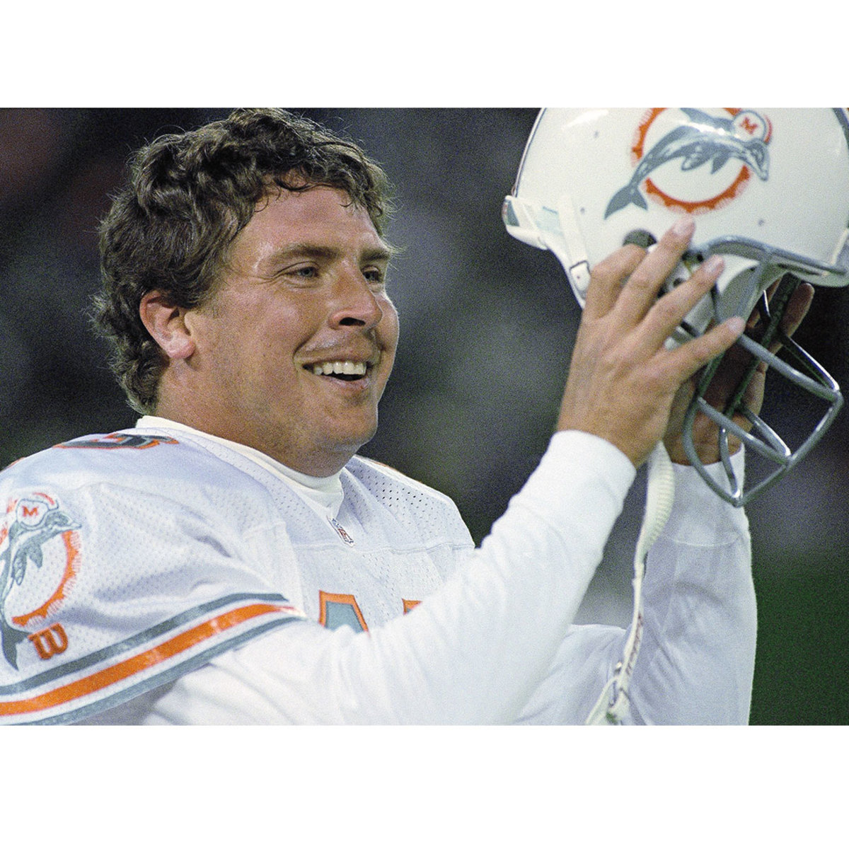 Miami Dolphins football player taking helmet off