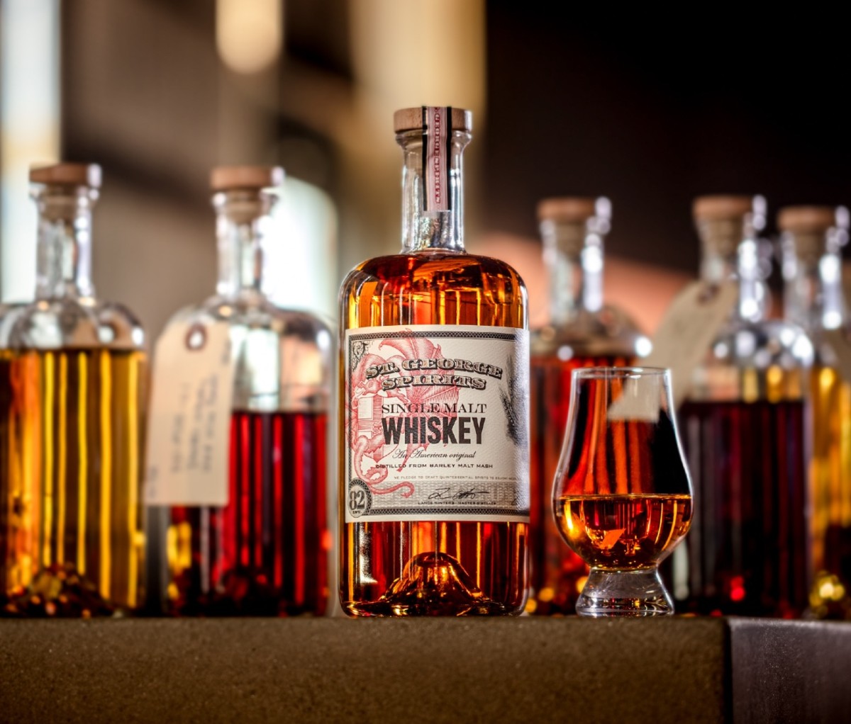 Bottle and glass of St. George 40th Anniversary Edition Single Malt Whiskey among other vessels of whiskey