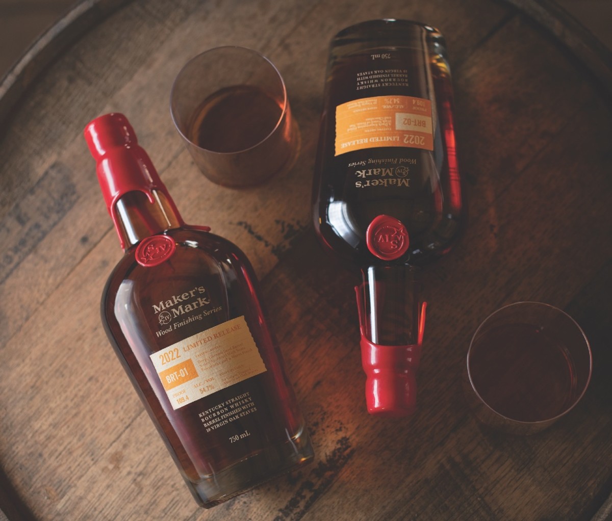 Two bottles of Maker’s Mark Wood Finishing Series lying on table