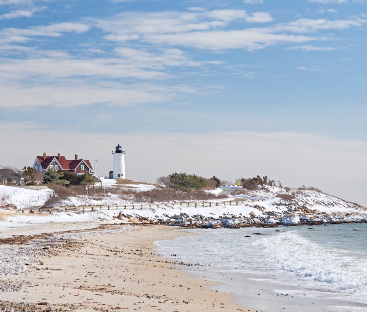 Winter coastal scene with lighthouse on the shore of Cape Cod, MA.
